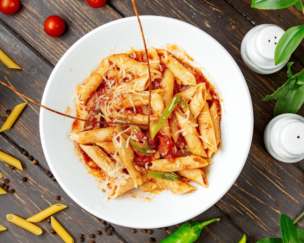 About Us 4 top view penne pasta with tomato